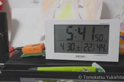 M5StickCとJJYアンテナ基板を電波時計の横に置いた様子